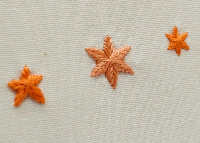 Punto de estrella tejido - bordado de estrellas rellenas con hilo naranja