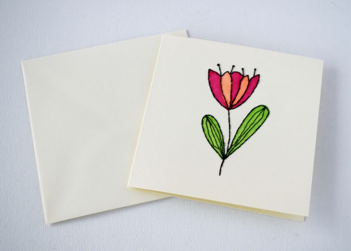 Tarjeta bordada a mano con una flor para el día de la madre